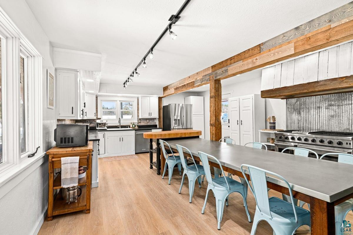 27 West Stark Road Esko, MN 55733 - Photo 13 of 47 Kitchen featuring white cabinets, light wood-style flooring, dark countertops, stainless steel appliances, and track lighting
