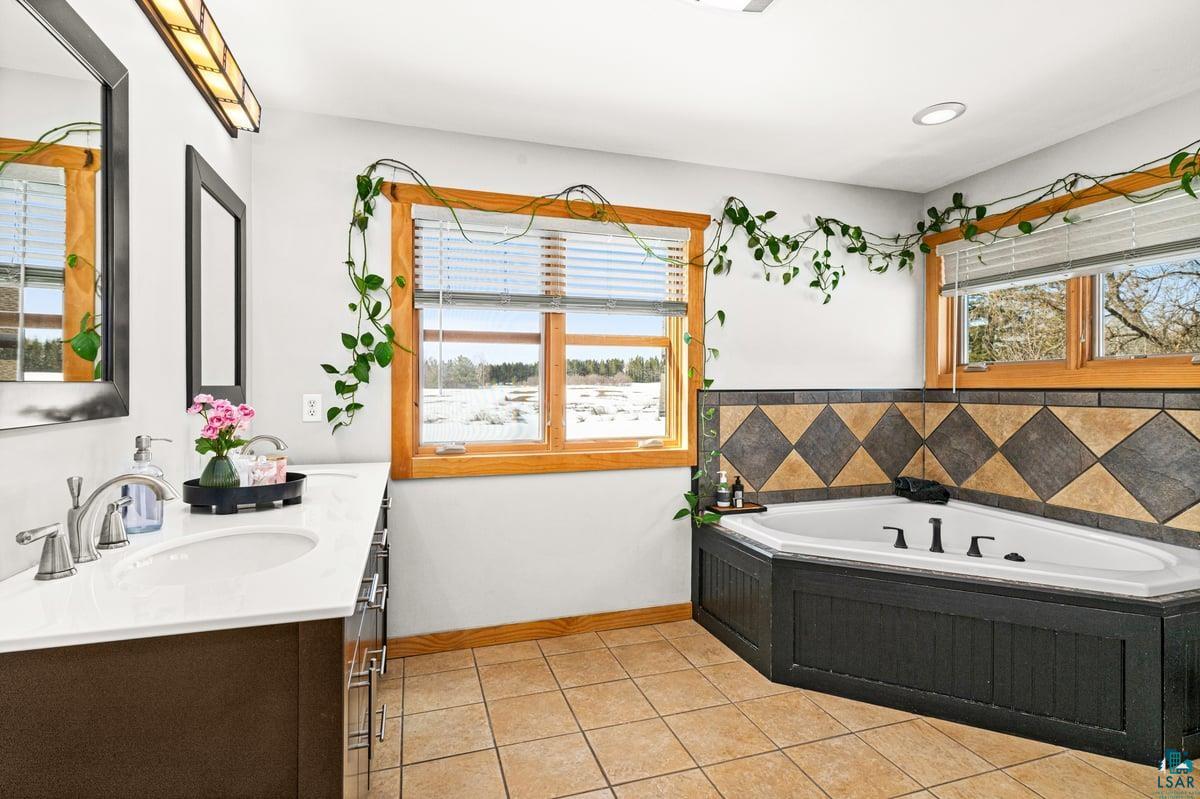 27 West Stark Road Esko, MN 55733 - Photo 22 of 47 Full bath with vanity, a bath, and light tile patterned flooring