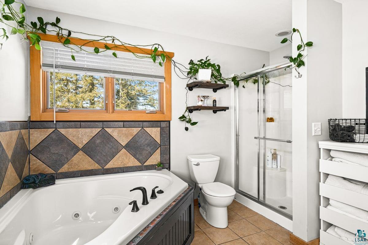 27 West Stark Road Esko, MN 55733 - Photo 23 of 47 Full bathroom with a tub with jets, a stall shower, and light tile patterned floors