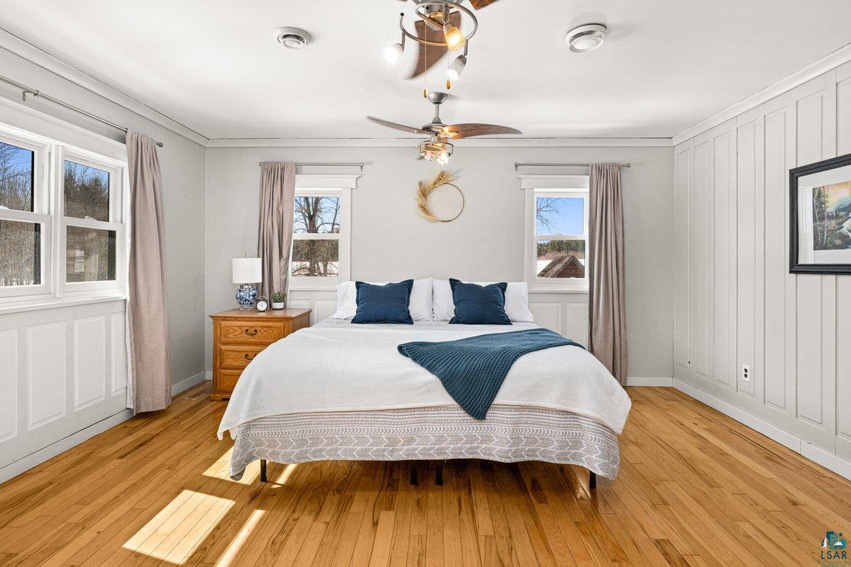 27 West Stark Road Esko, MN 55733 - Photo 25 of 47 Bedroom featuring light wood-style floors, a ceiling fan, and ornamental molding