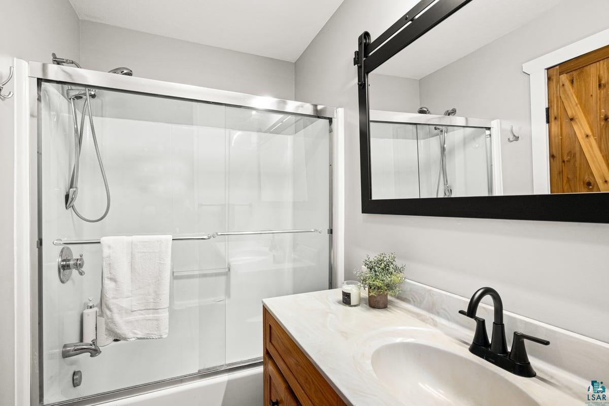 27 West Stark Road Esko, MN 55733 - Photo 31 of 47 Bathroom featuring vanity and bath / shower combo with glass door