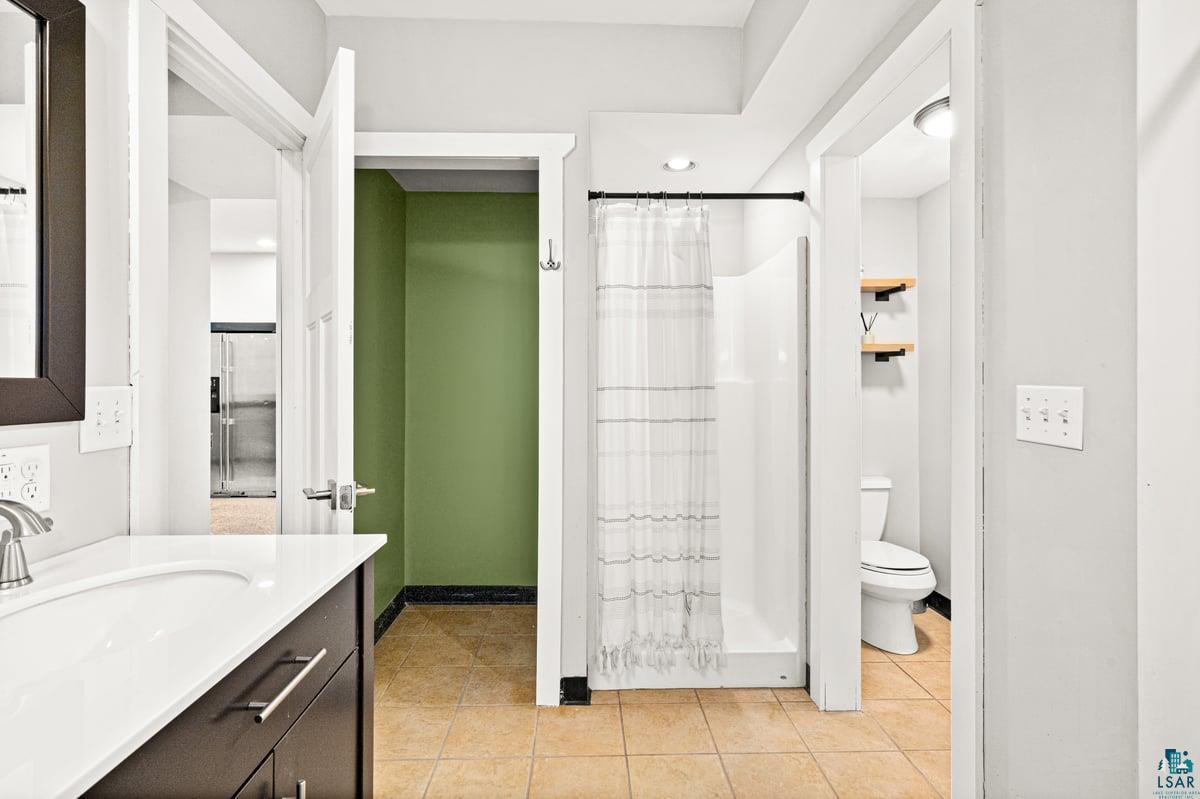 27 West Stark Road Esko, MN 55733 - Photo 32 of 47 Bathroom with vanity, a shower with shower curtain, light tile patterned floors, and recessed lighting