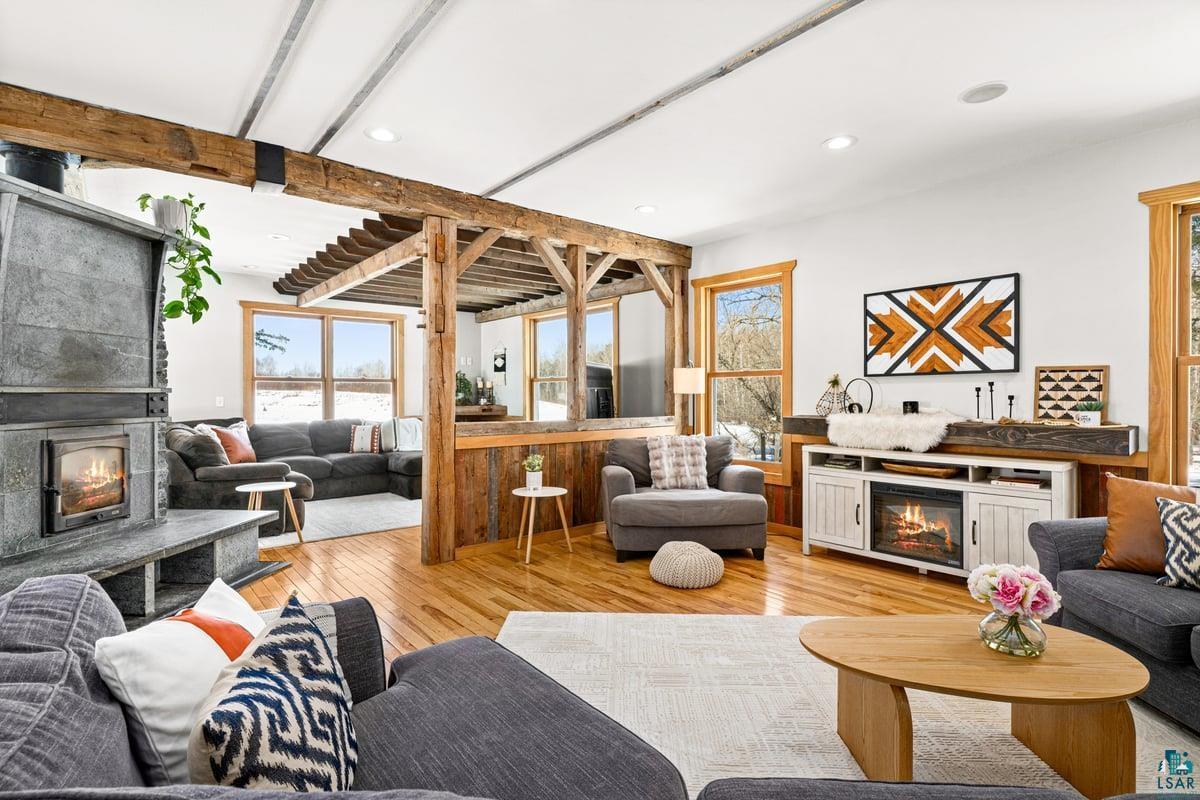 27 West Stark Road Esko, MN 55733 - Photo 5 of 47 Living room featuring a lit fireplace, light wood-style floors, beam ceiling, and recessed lighting