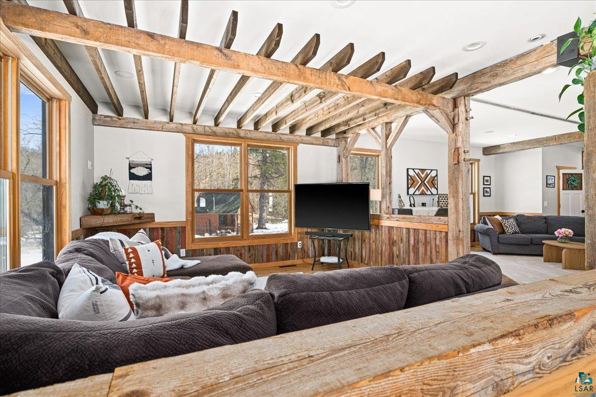 27 West Stark Road Esko, MN 55733 - Photo 9 of 47 Living room with a wainscoted wall, wood walls, beam ceiling, and recessed lighting