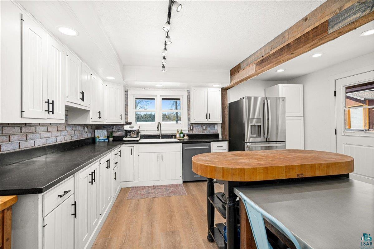 27 West Stark Road Esko, MN 55733 - Photo 10 of 47 Kitchen with white cabinetry, stainless steel appliances, light wood-style floors, dark countertops, and recessed lighting