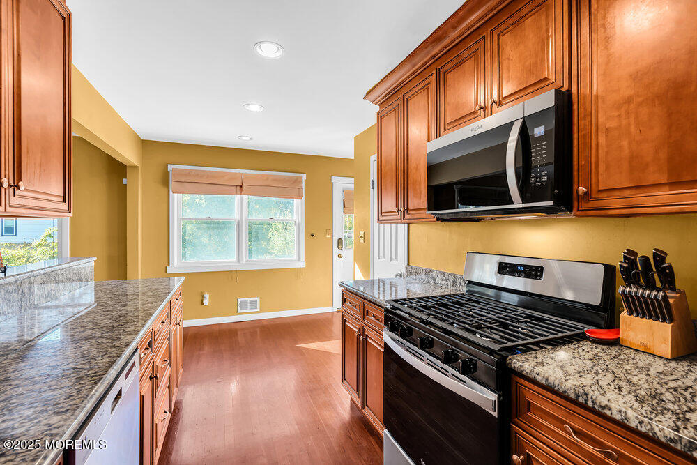 345 Green Grove Road Tinton Falls, NJ 07712 - Photo 19 of 80 a kitchen with stainless steel appliances granite countertop a stove a sink and a microwave