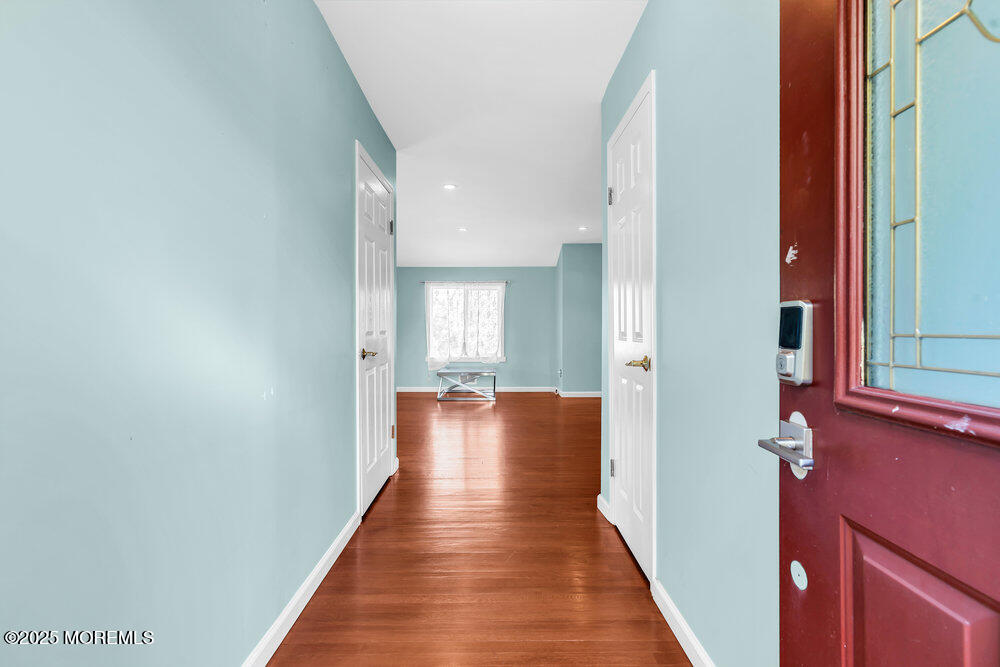 345 Green Grove Road Tinton Falls, NJ 07712 - Photo 4 of 80 a view of a hallway with wooden floor and staircase