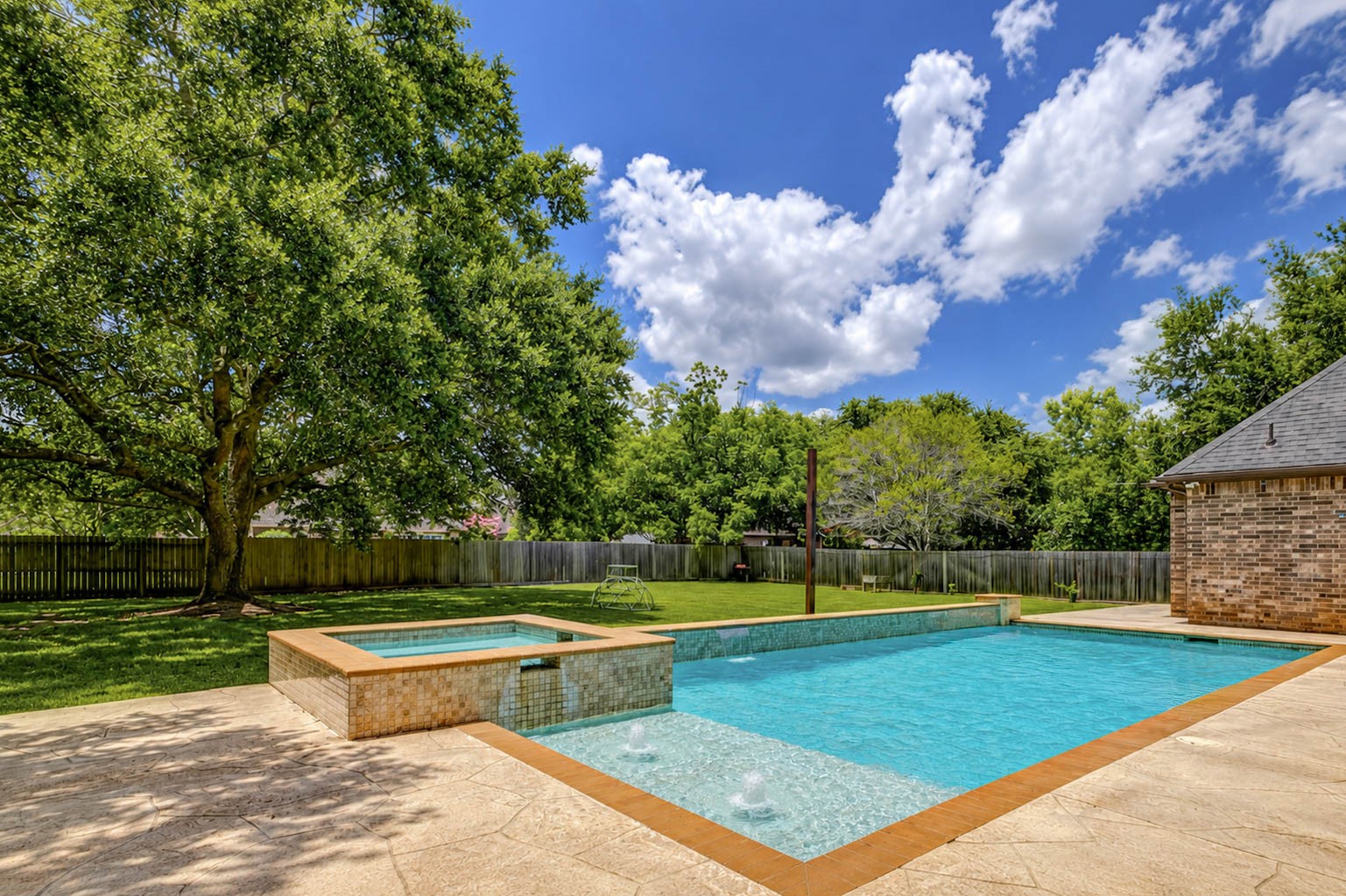 5327 Whitmore Fulshear, TX 77441 - Photo 3 of 50 The pool's tanning ledge provides the perfect spot to lounge and soak up the sun while enjoying the peaceful surroundings.