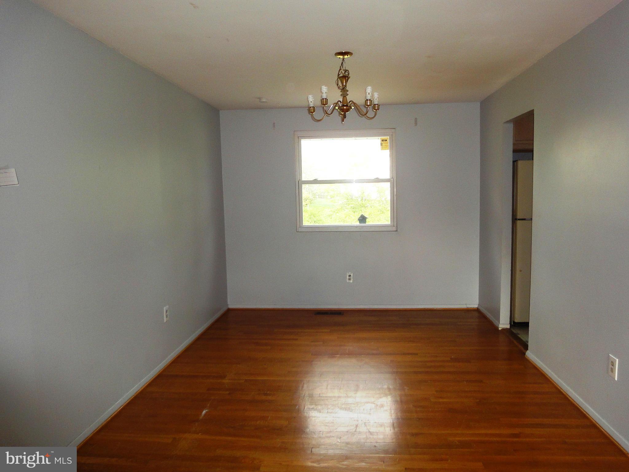 3905 Zurich Road Randallstown, MD 21133 - Photo 5 of 13 a view of an empty room with wooden floor and a window