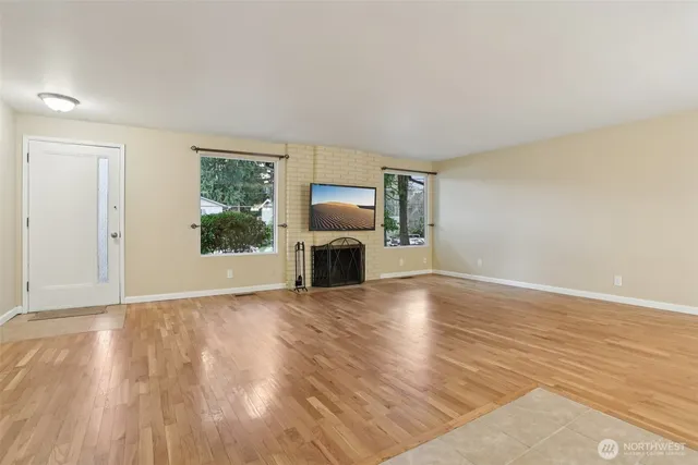 a view of a livingroom with wooden floor and a fireplace