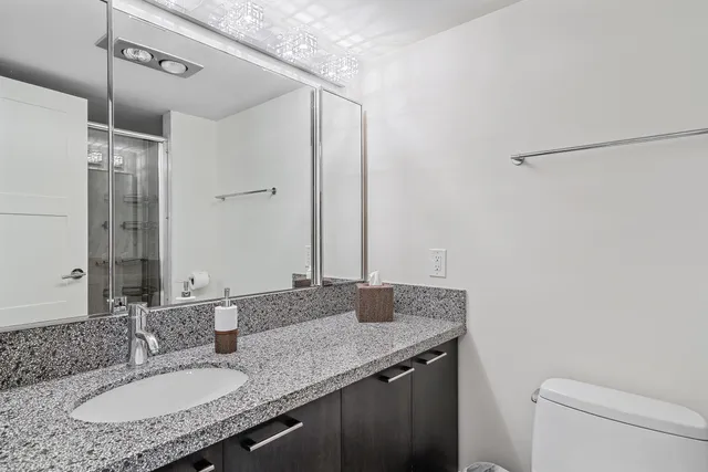 a bathroom with a granite countertop sink and a mirror