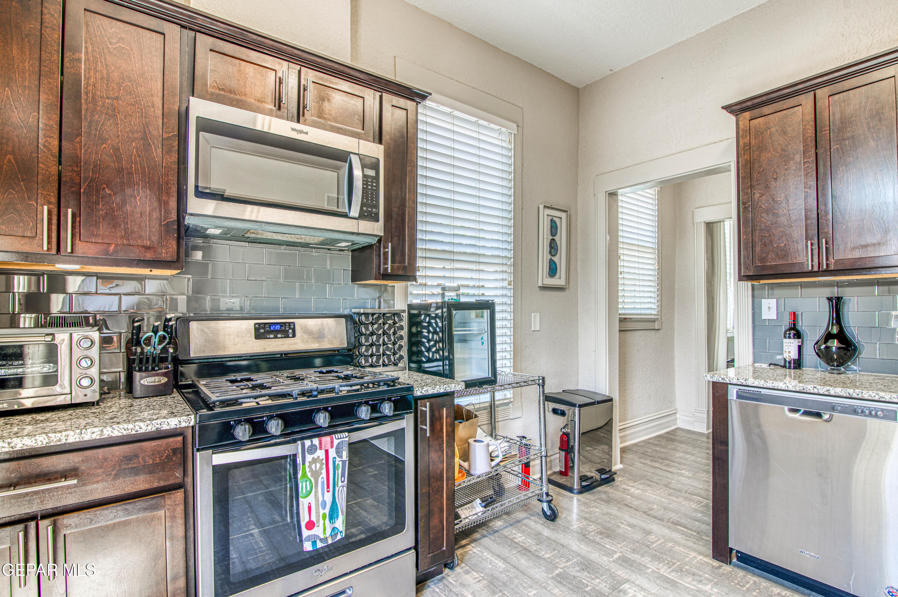 640 Stewart Court El Paso, TX 79902 - Photo 11 of 31 a kitchen with stainless steel appliances granite countertop a stove top oven a sink dishwasher and cabinets with wooden floor