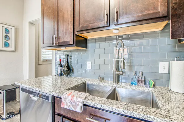 a kitchen with granite countertop a sink and a stove