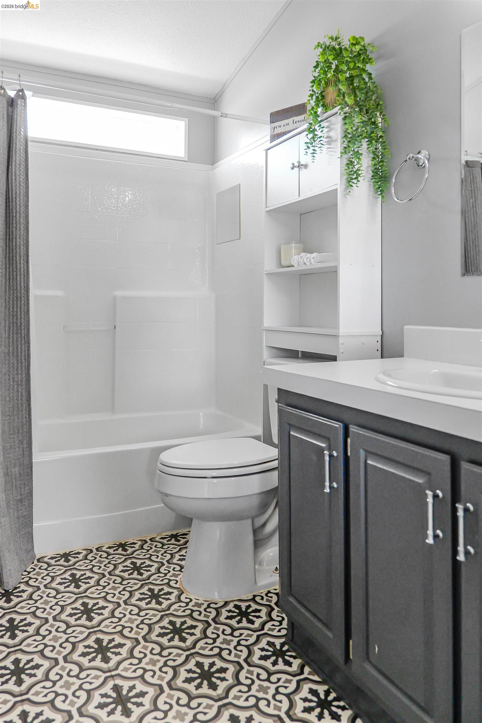 4419 Little John Road Copperopolis, CA 95228 - Photo 15 of 43 Bathroom featuring a patterned tile floor, a built-in bathtub with shower, a vanity with dark cabinetry, a white countertop, and a built-in storage cabinet