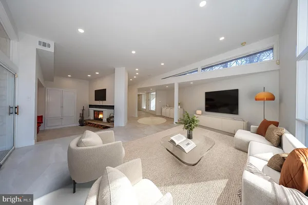 a living room with furniture kitchen view and a potted plant