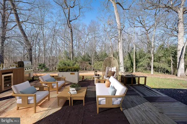 a view of a patio with couches table and chairs and wooden floor