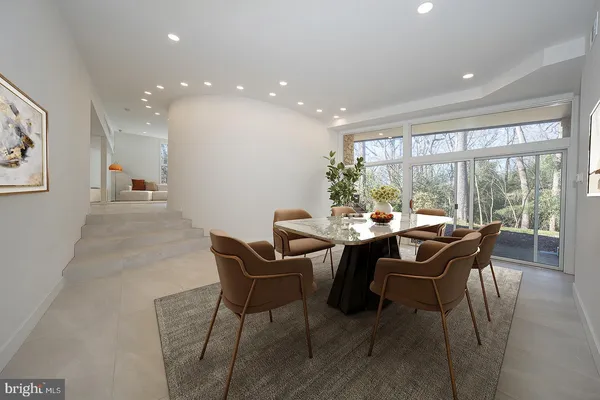 a view of a dining room and livingroom with furniture wooden floor and a large window