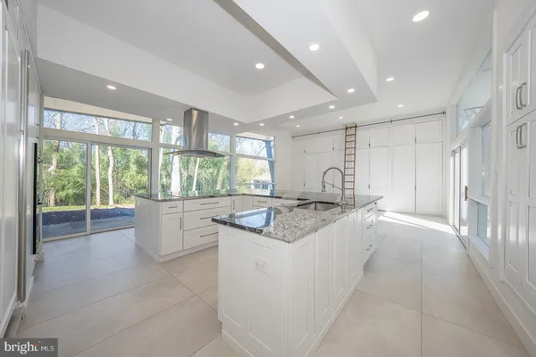 a kitchen with kitchen island granite countertop a sink and stove in it