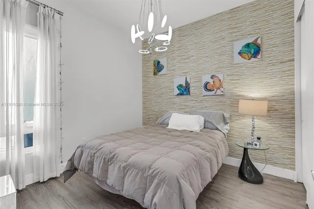 a bedroom with a bed and a chandelier