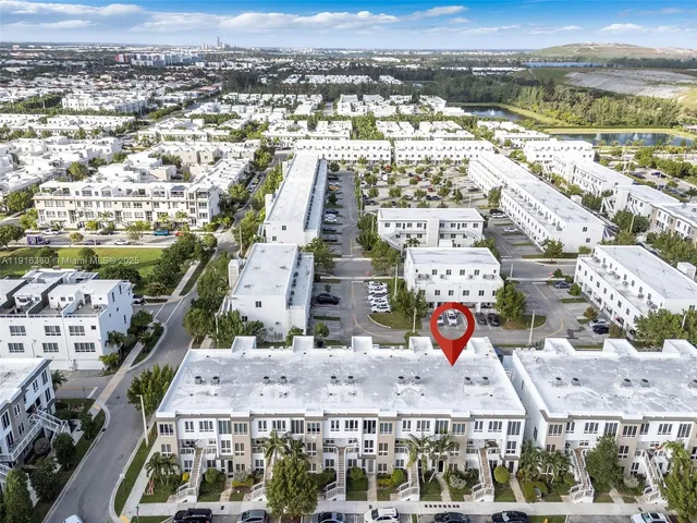 a view of swimming pool with a yard and palm trees