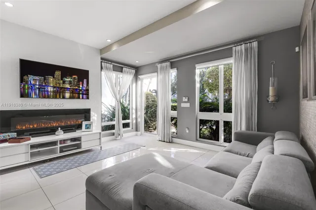 a living room with furniture a flat screen tv and a fireplace