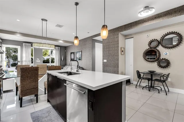a open kitchen with a sink a island and chairs