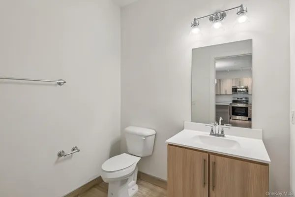 a bathroom with a granite countertop toilet a sink and a mirror