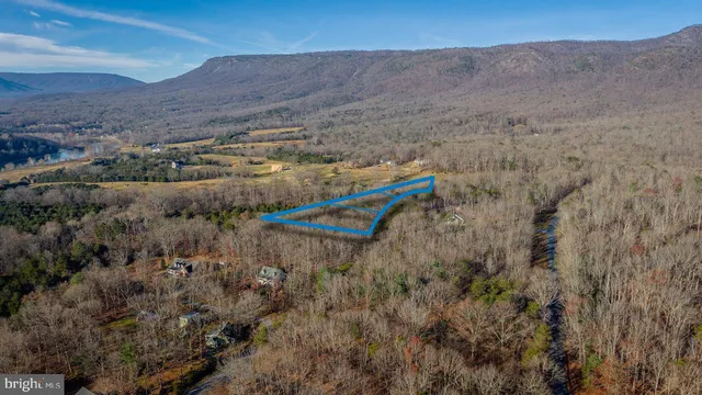 a view of a dry yard with mountains in the background