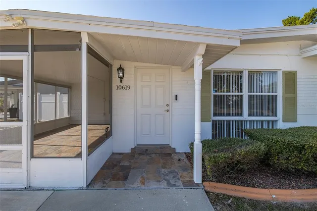 a view of a house with backyard and trees