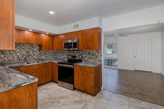 a kitchen with stainless steel appliances granite countertop a sink and a stove top oven