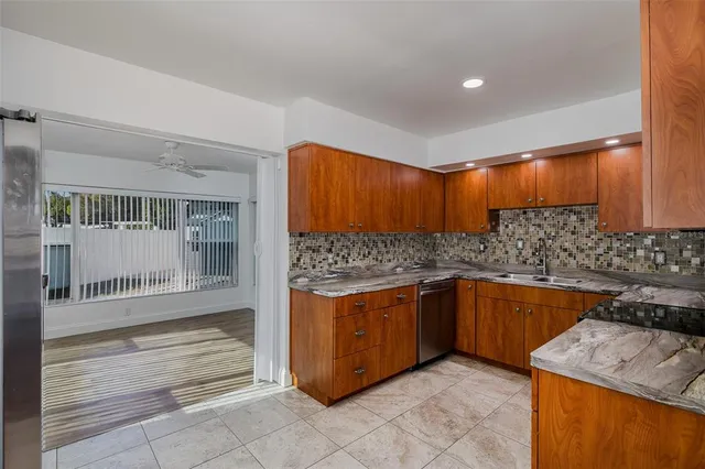 a kitchen with stainless steel appliances granite countertop a refrigerator and a sink