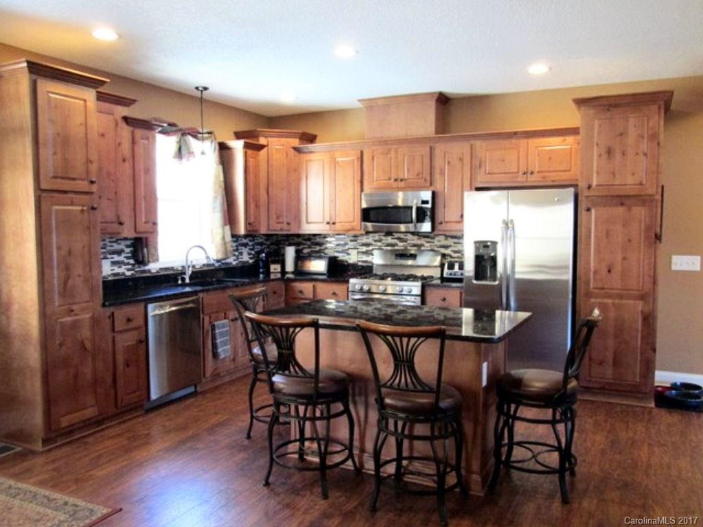 31 Lick Log Road Sylva, NC 28779 - Photo 9 of 24 a kitchen with stainless steel appliances a dining table chairs stove refrigerator and cabinets