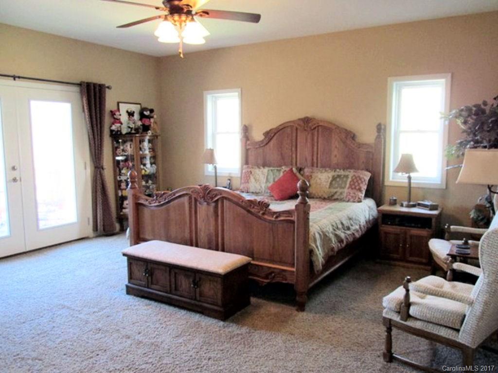 31 Lick Log Road Sylva, NC 28779 - Photo 10 of 24 a spacious bedroom with a bed and a chandelier