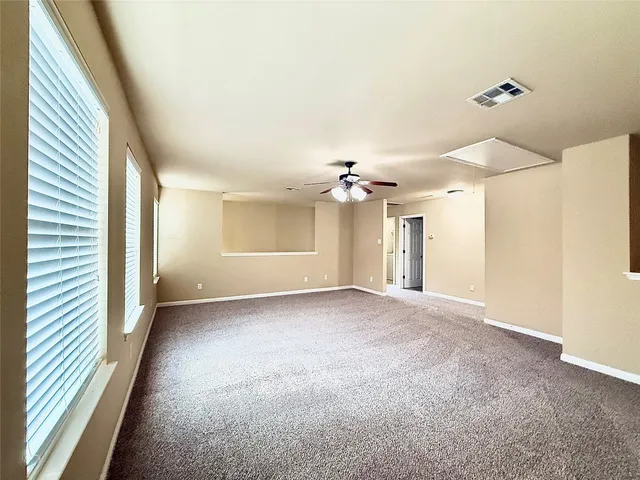 a view of a big room with windows and chandelier fan