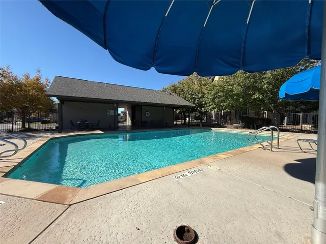a view of a backyard with table and chairs under an umbrella