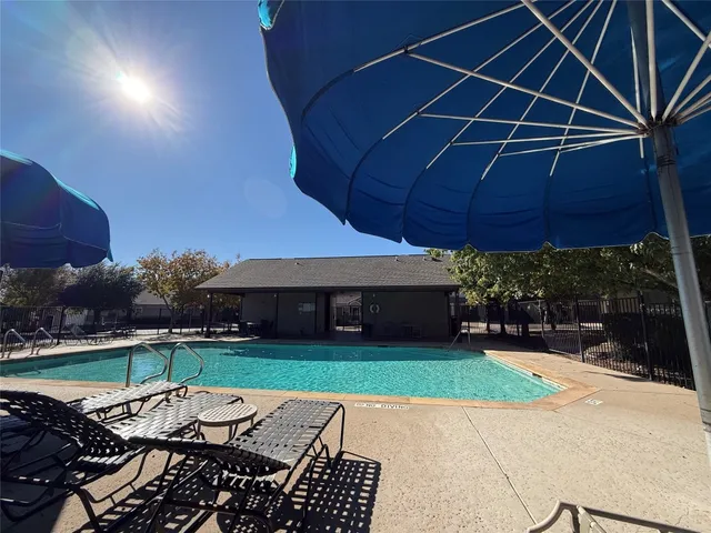 a view of a backyard with table and chairs under an umbrella