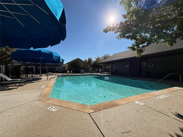 a view of a patio with a table and chairs under an umbrella