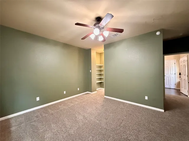 an empty room and chandelier fan