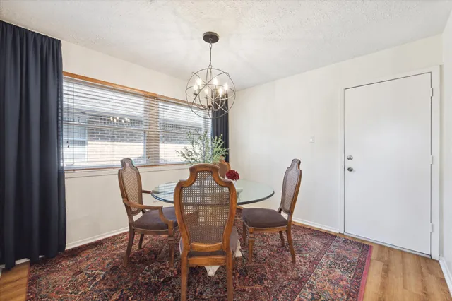a dining room with furniture a chandelier and wooden floor
