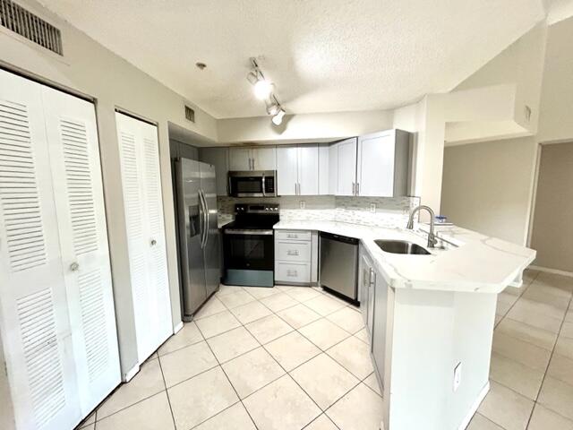 741 North Pine Island Road, Unit 303 Plantation, FL 33324 - Photo 9 of 32 a kitchen with a sink a stove a refrigerator and cabinets
