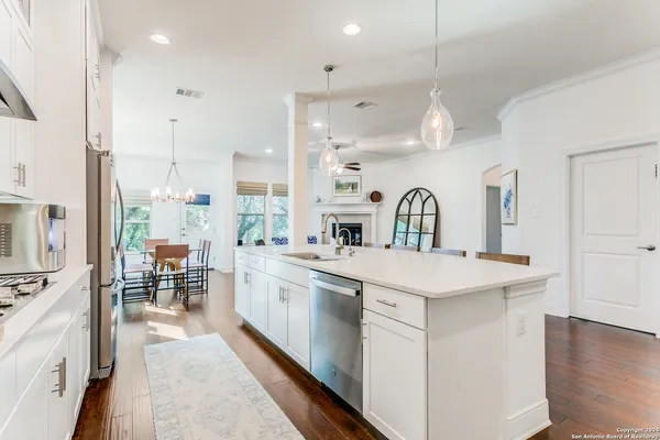 a large kitchen with kitchen island a sink appliances and a counter top space