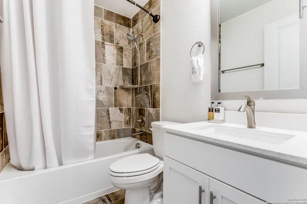 a bathroom with a sink a toilet and shower