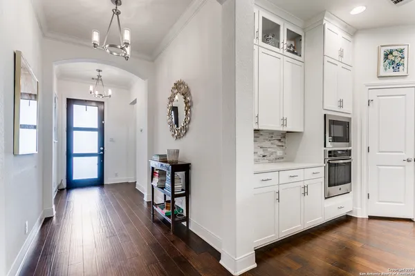 a hallway with cabinets and wooden floor