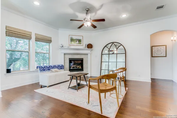 a living room with furniture a fireplace and a floor to ceiling window
