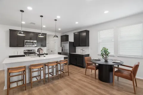 a large kitchen with a table and chairs in it