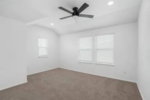 an empty room with windows and ceiling fan