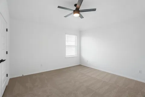 an empty room with a window and a fan