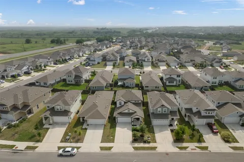 an aerial view of residential houses with outdoor space and ocean