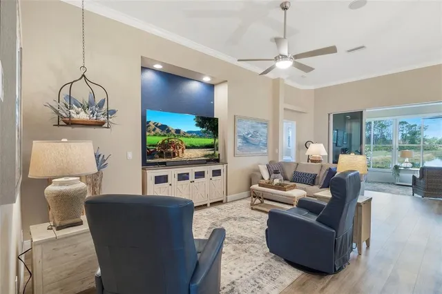 a living room with furniture kitchen view and a chandelier