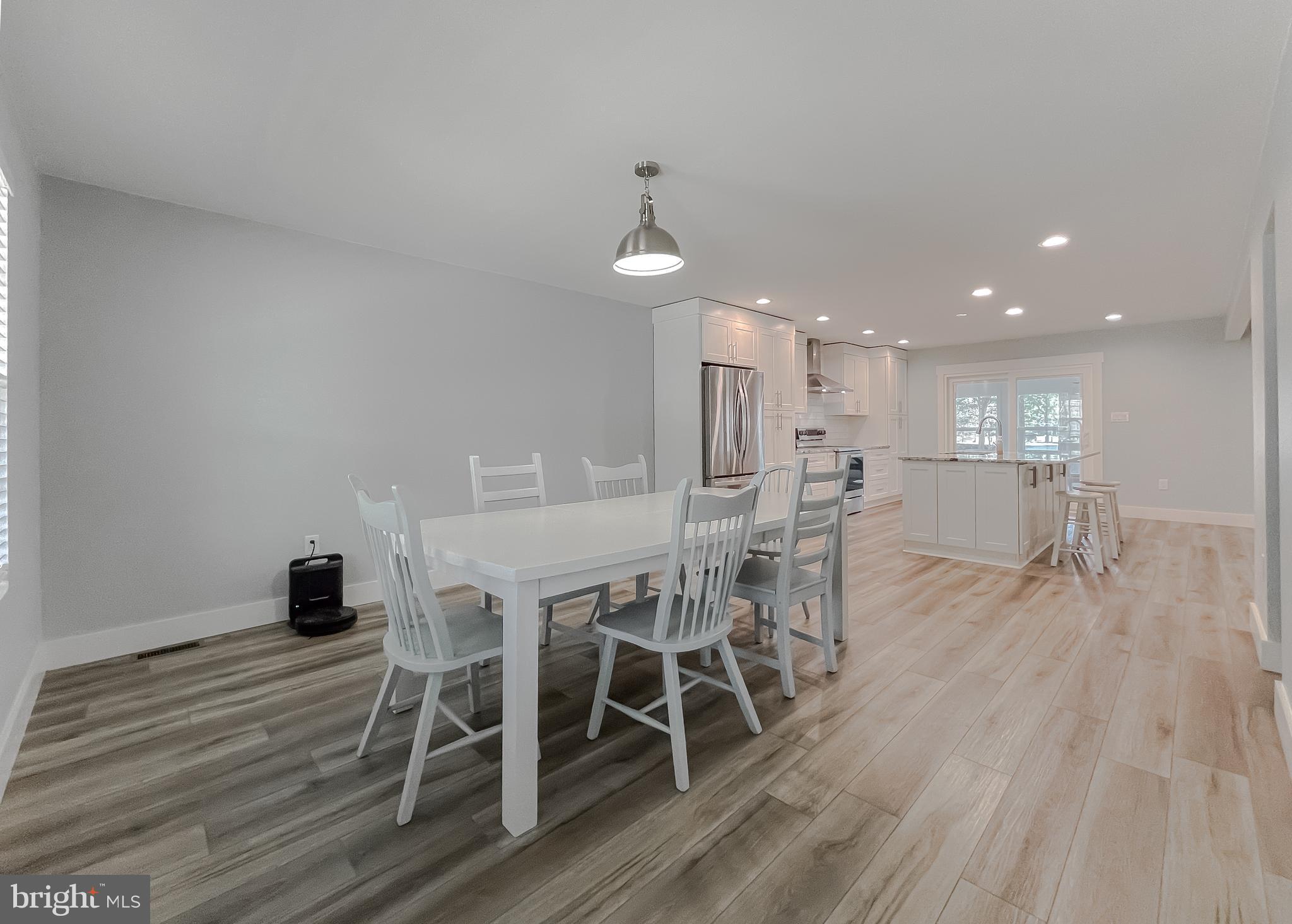 13630 Dowell Road Solomons, MD 20657 - Photo 103 of 121 a dining room with furniture wooden floor a rug and a mirror